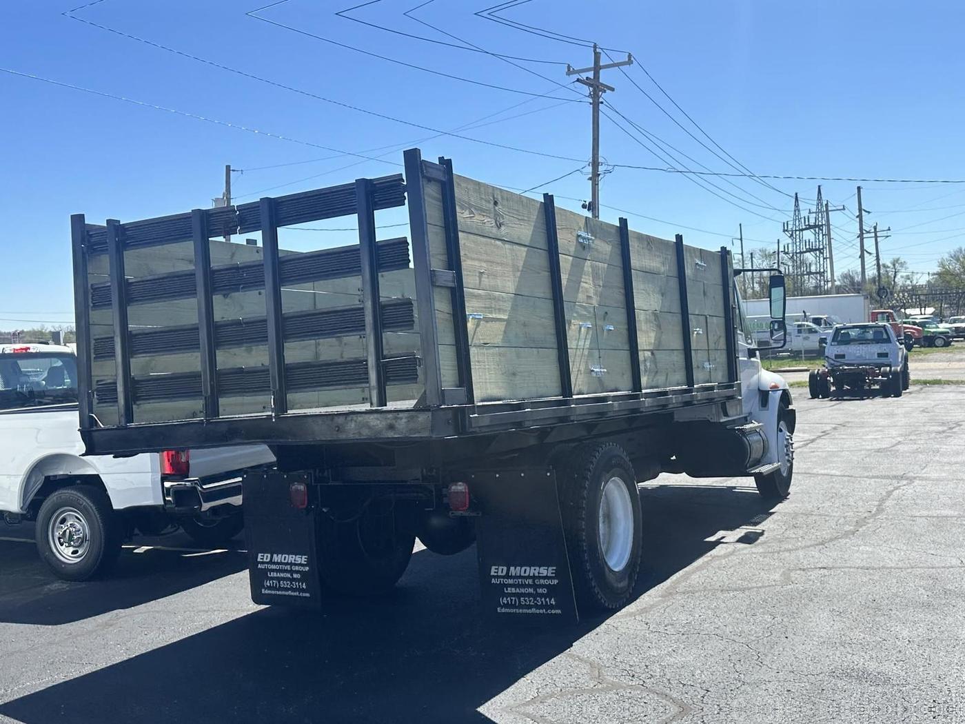 A stake-bed truck body T&T built, fresh timber sides on a medium-duty truck outside the Lebanon shop
