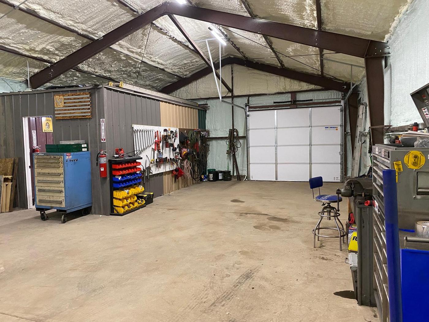 Shop interior with tool walls, parts bins and a bay door